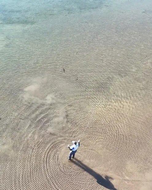 Vista aérea de pescador en aguas bajas